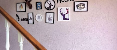 A wall with various framed pictures and the word 'House' prominently displayed.