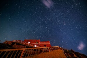 A night sky with stars, a red building, and a staircase. - Haiyi Jiage Inn (Shengsi)