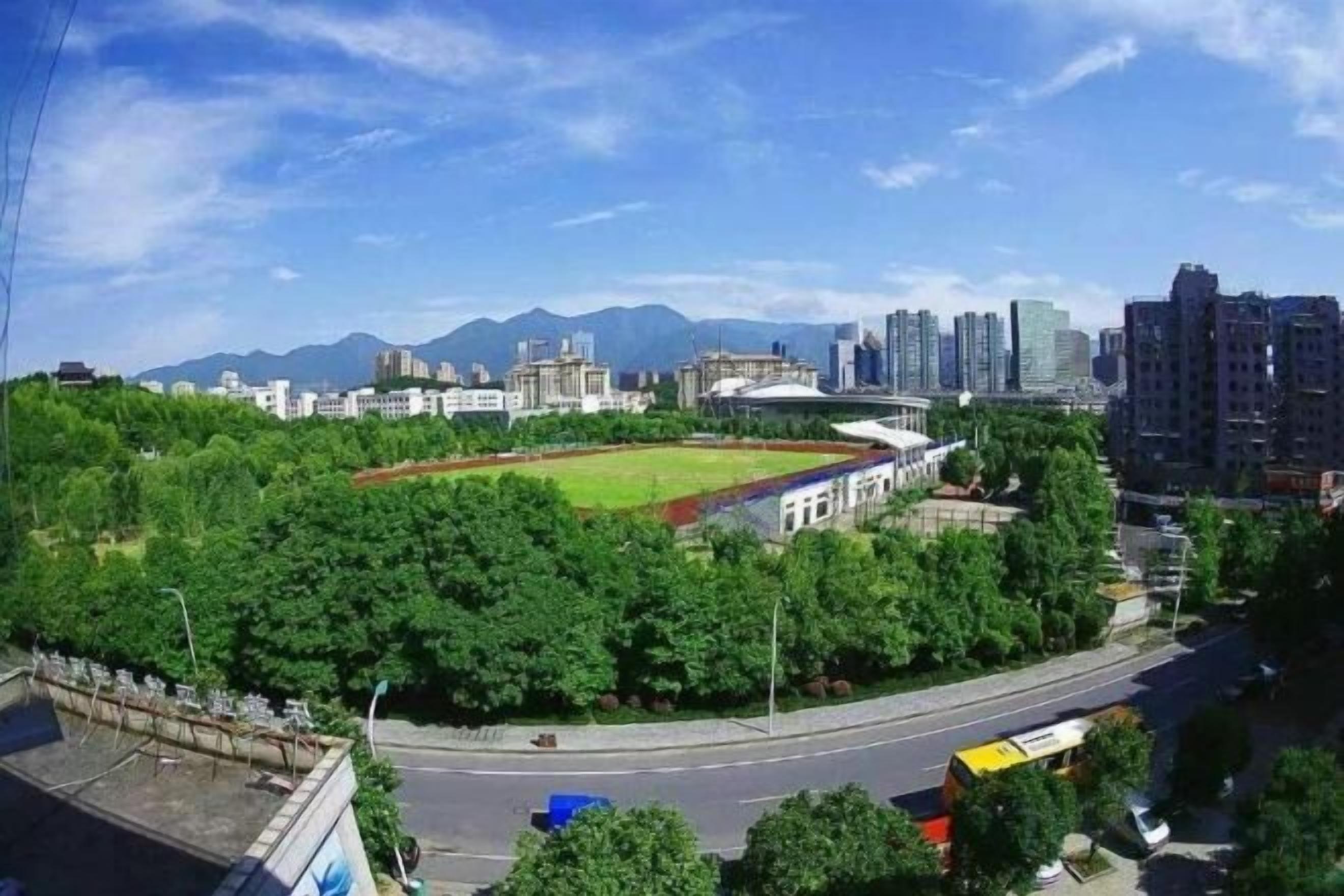 A cityscape with a green park, a sports field, and modern buildings.