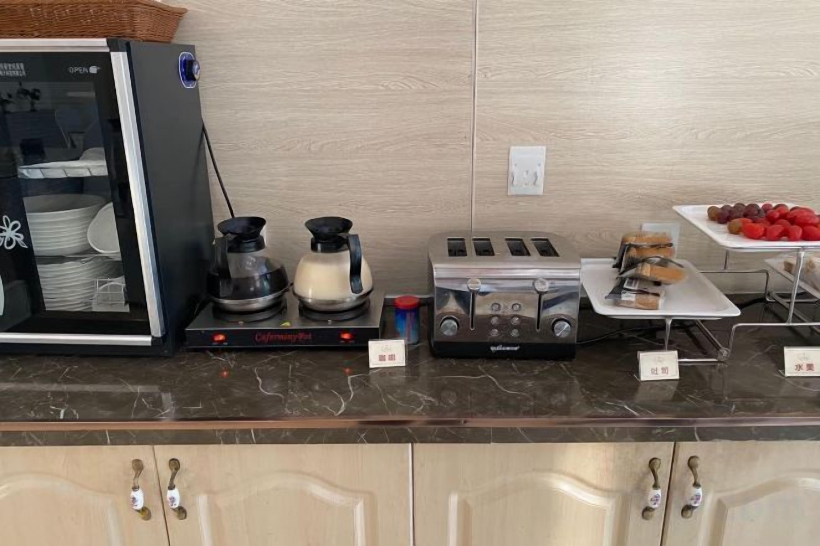 Eine Küchenzeile mit Kaffeemaschine, Toaster und einem Teller Essen.