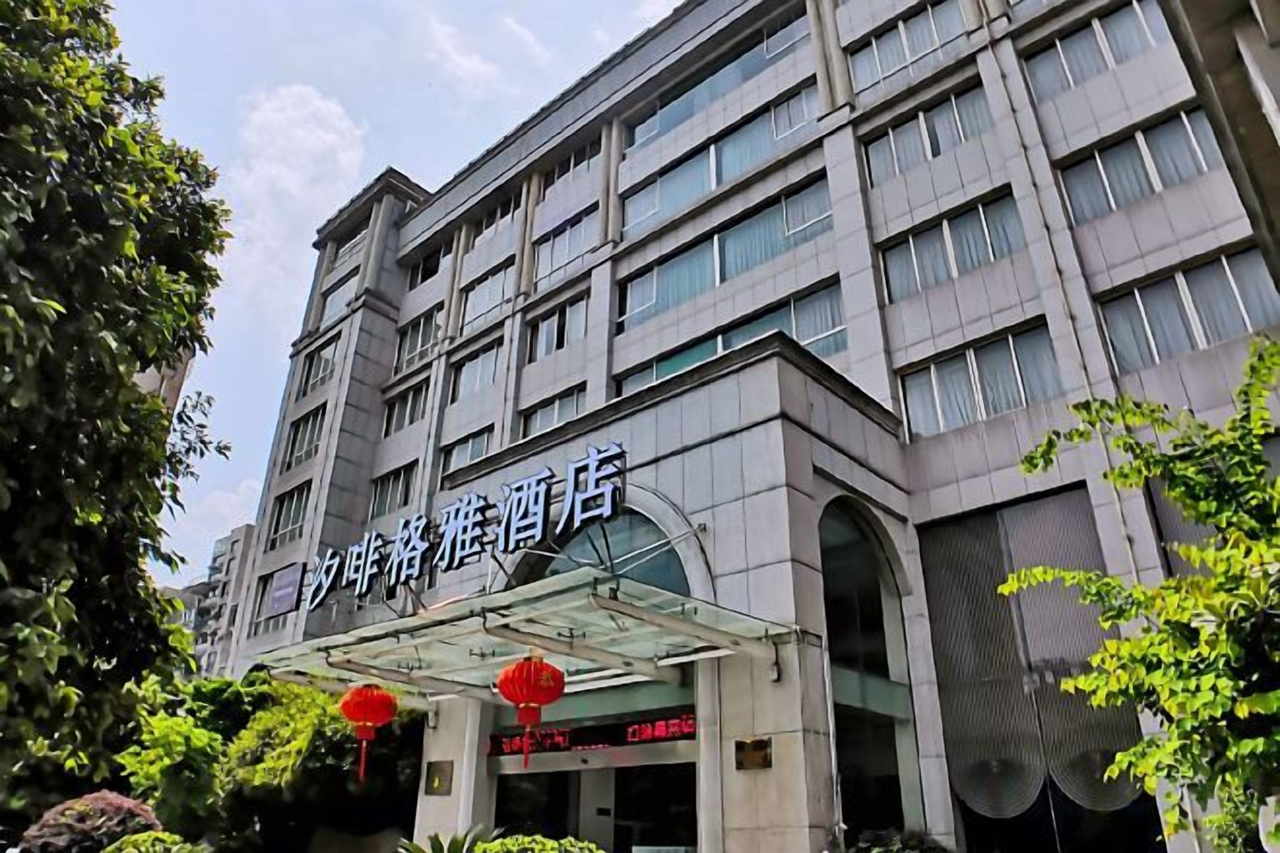 A multi-story hotel building with a covered entrance and signage.