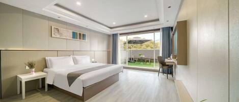 A modern hotel room with a large bed, a desk, and a balcony with a view.