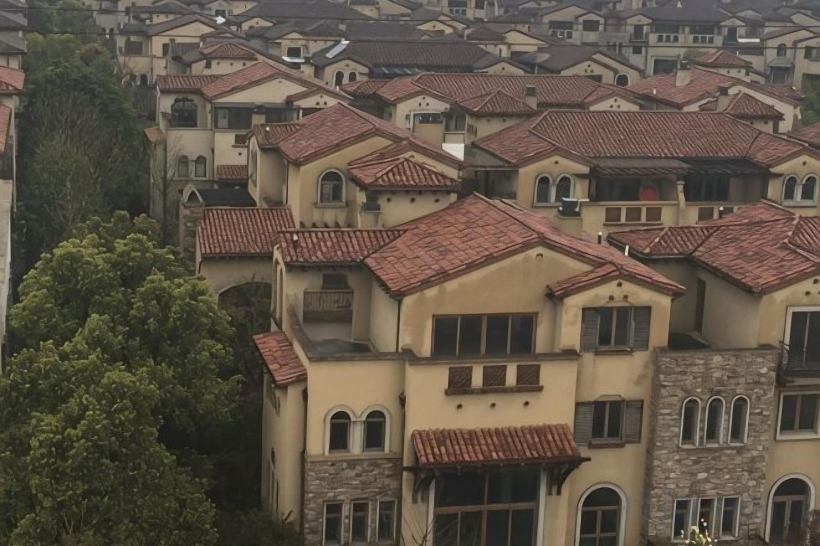 Quartiere residenziale con diverse case caratterizzate da tetti in tegole rosse e muri color crema.