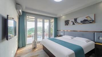 A hotel room with a bed, a flat-screen TV, a window with curtains, and a ceiling light.