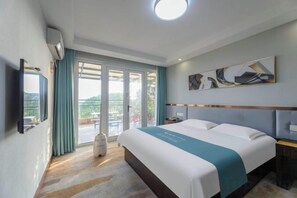 A hotel room with a bed, a flat-screen TV, a window with curtains, and a ceiling light. - Chamagudao Hotel (Ningbo)