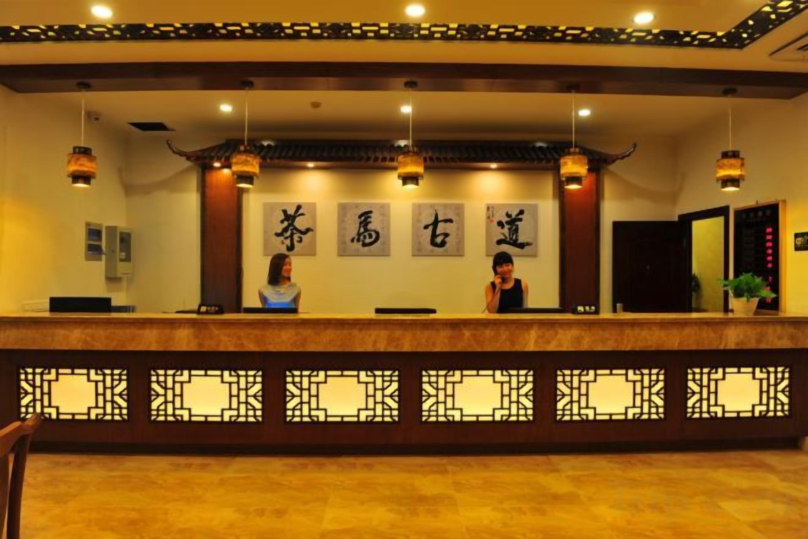 A reception desk with a traditional design, featuring a patterned barrier and hanging lights.
