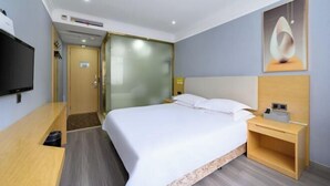 A hotel room with a bed, a desk, a TV, and a painting on the wall. - Xianggang Hudie Hotel (Anqing)