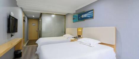 Quarto de hotel com duas camas, uma televisão, um quadro e um banco de madeira.