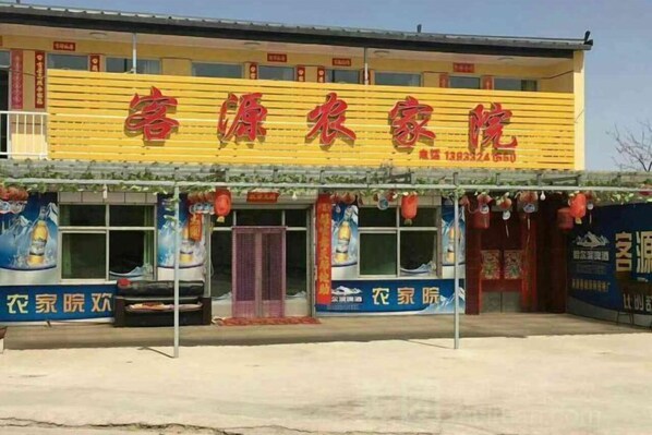 A building with a yellow facade and red signage. - Yiyuan Keyuan Farm House (Laiyuan)