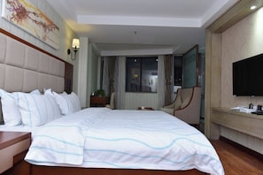 A hotel room with a large bed, a television, a desk, and a chair. - Olive Tree Hotel(Xuhai Times Jianyang Middle School Square) (Jianyang)
