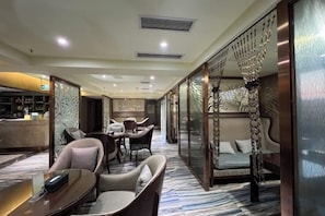 A hotel lobby with a dining area, seating arrangements, and a reception desk. - Olive Tree Hotel(Xuhai Times Jianyang Middle School Square) (Jianyang)