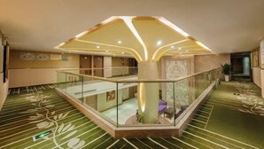 A spacious lobby with a central column, glass railings, and patterned flooring. - Olive Tree Hotel(Xuhai Times Jianyang Middle School Square) (Jianyang)