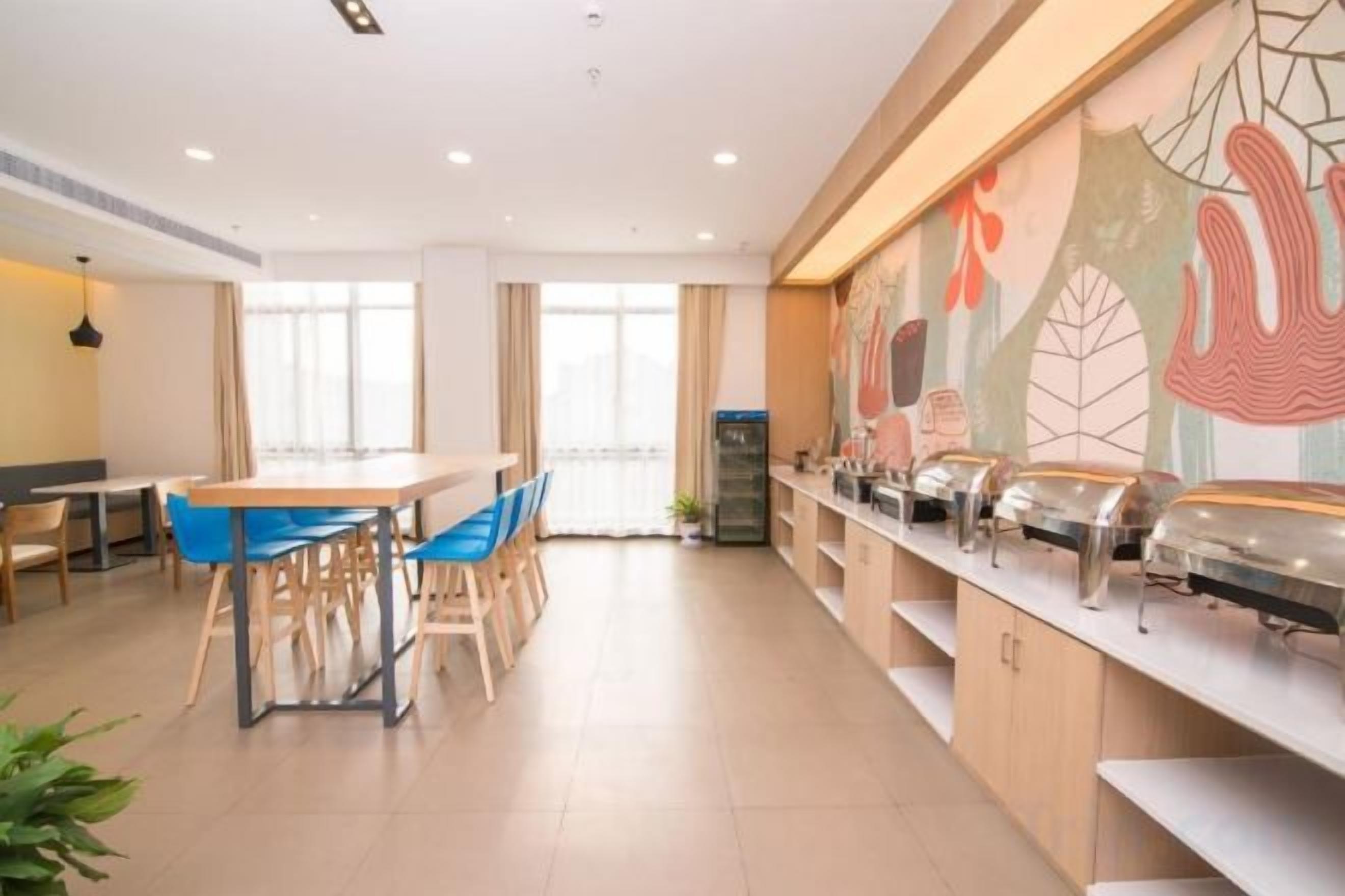 A modern dining area with a long counter, chairs, and a table.