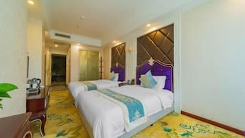 Habitación de hotel con dos camas, un escritorio y un espejo.