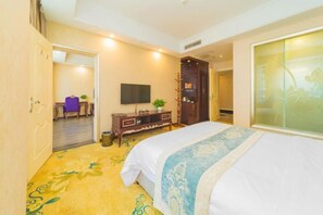 A hotel room with a bed, a TV, a wardrobe, and a door leading to another room. - Junyi Chain Hotel (Sichuan Media College) (Chengdu)