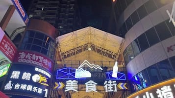 Un edificio con varios letreros iluminados, incluyendo uno para un restaurante y otro para un hotel.