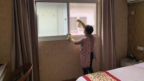 A room with a bed, a window, and a small table. - Jixi School Hotel (Jixi)