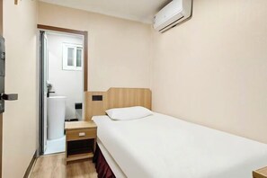 A small, single-bed room with a wooden headboard, a bedside table, a drawer, and a white wall-mounted air conditioner. - Haoyun Hotel (Nanshida People's Hospital) (Nanjing)