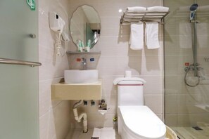 Un baño con lavamanos, espejo, toallero y ducha.