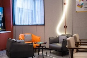A modern hotel lobby with leather seating, a small table, and a large window with sheer curtains. - Super 8 Collection Hotel Beijing Guomao Baiziwan Subway Station (Beijing)
