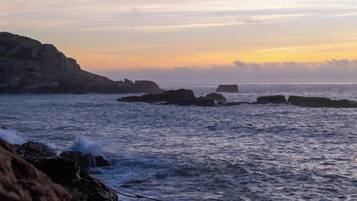 A coastal landscape with rocky formations and calm sea.