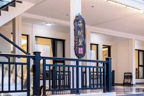 L’intérieur d’un hôtel avec un escalier, une enseigne avec des caractères chinois et un design moderne.