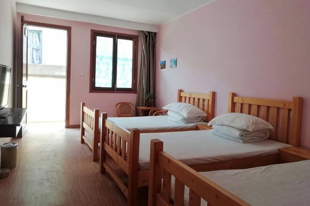 Una habitación con dos camas de madera, un escritorio y una silla.