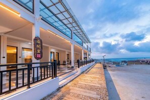 Un hôtel doté d’une galerie couverte, d’un espace extérieur aménagé et offrant une vue sur la plage.