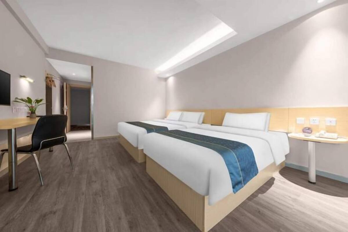 Een moderne hotelkamer met een groot bed, een bureau en een stoel.