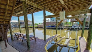 A wooden deck with picnic tables and a water feature. - New For 2025 - Waterfront Bayou Retreat: 25 Min to NOLA. (Barataria)