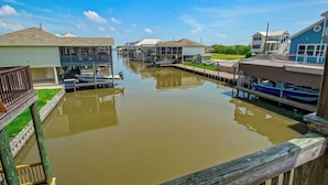 A canal with houses on either side, a wooden dock, and a clear sky. - New For 2025 - Waterfront Bayou Retreat: 25 Min to NOLA. (Barataria)