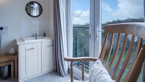 A bathroom with a sink, mirror, and window. - Little Glen - 3 Bedroom Holiday Home - Tenby (Tenby)