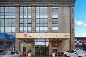 A hotel entrance with a large sign, multiple windows, and a few cars parked in front. - Shencheng Hotel (Xuancheng RT Mart Branch) (Xuancheng)