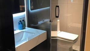 A modern bathroom with a glass-enclosed shower, a white sink, and a toilet. - Foshan Shunde Weierke Hotel (Lunjiao Recreation Center) (Foshan)