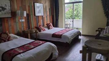 A hotel room with two beds, a wooden wall, a window, and a small round table.