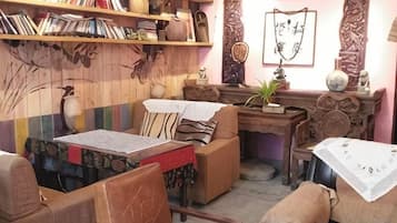 Ein gemütliches Zimmer mit einer Holzwand, einem Bücherregal, einem Schreibtisch und einem Sofa.