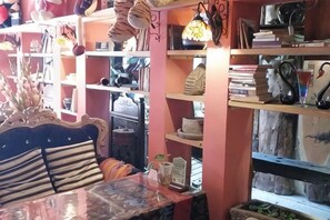 A room with a bed, a table, and shelves filled with books and decorative items. - Banduo Youlian Hostel (Shanghai)
