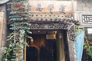 Una entrada de edificio tradicional con tallados ornamentales y un cartel.