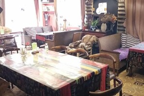 A hotel lobby with a large dining table, several sofas, and a patterned carpet. - Banduo Youlian Hostel (Shanghai)