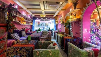 A cozy, colorful interior with patterned furniture and a central aisle leading to a counter.