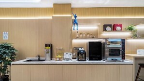 Una cocina moderna con armarios de madera, cafetera, microondas y tostadora.