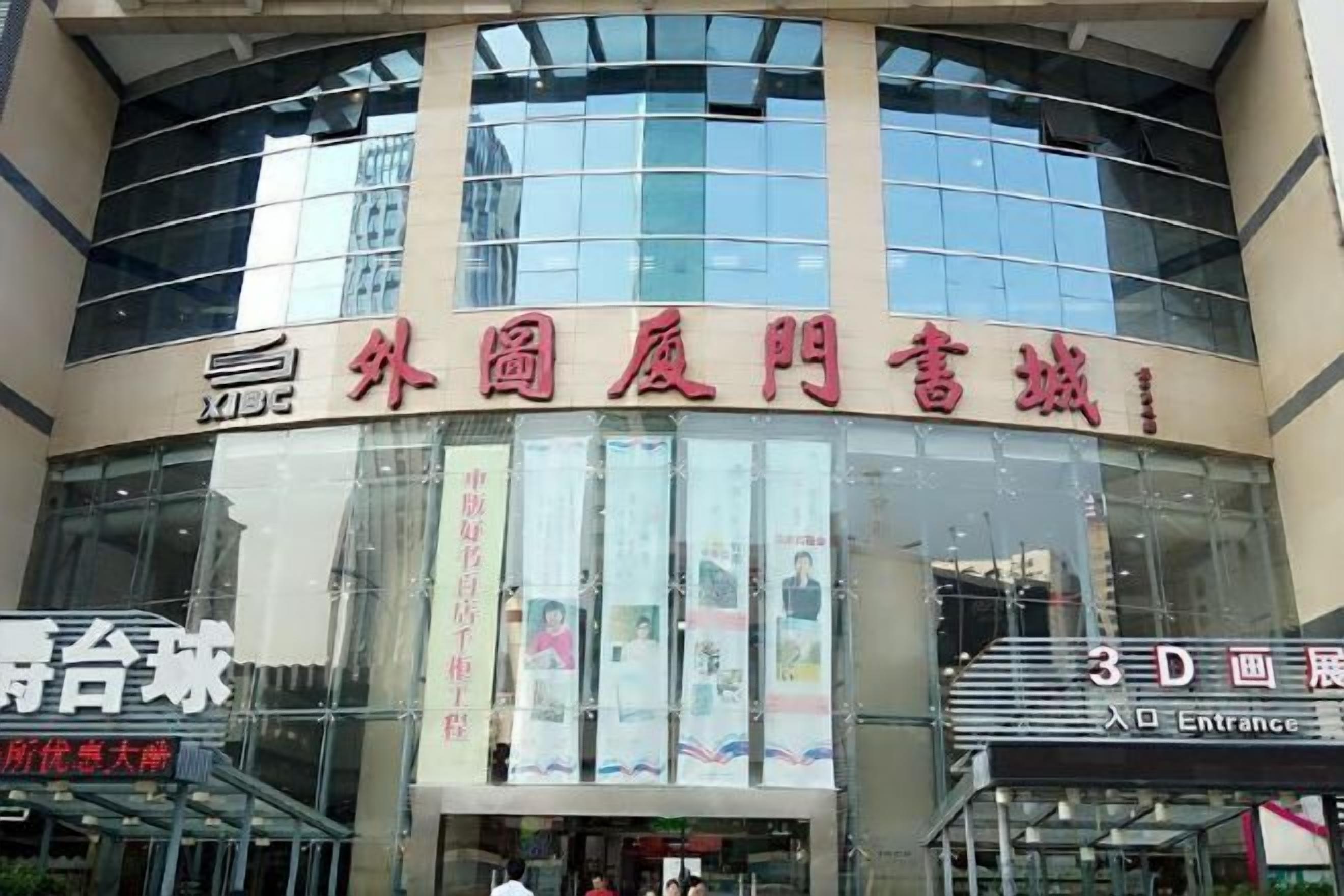 A building with a large glass facade, signage for '3D Cinema' and 'Entrance', and a banner with Chinese characters.