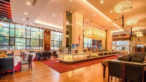 A spacious restaurant with a central counter, tables, and chairs arranged for dining. - Kunming Southwest Hotel (Kunming)