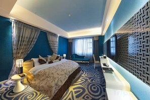 Une chambre d’hôtel avec un grand lit, un bureau et une vue sur la ville.