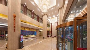 A spacious lobby with high ceilings, a reception desk, and a glass elevator. - Kunming Southwest Hotel (Kunming)