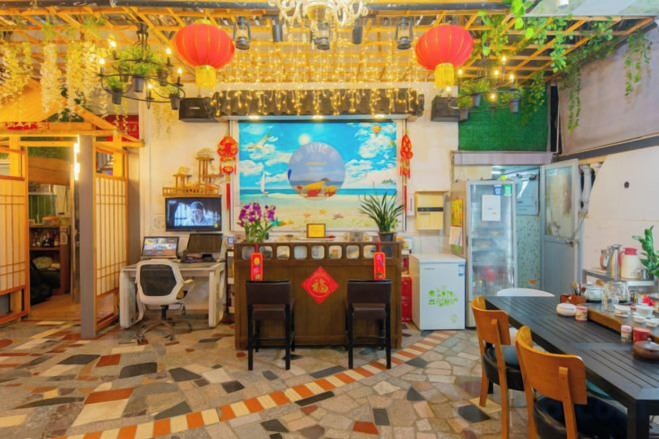A restaurant with a traditional Asian decor, a counter with stools, and a television screen.