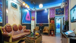 A modern living room with a sofa, chairs, a coffee table, and a TV. - HaiBei Hostel (Shenzhen)