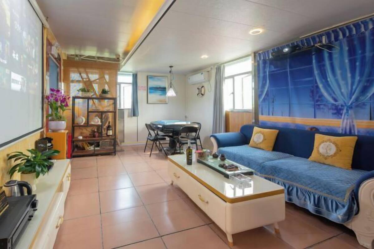 A living room with a sofa, coffee table, and a dining area with chairs.