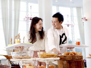 A breakfast buffet with various food items and a person serving. - Holiday Inn Resort MIYAZAKI by IHG (Miyazaki City)
