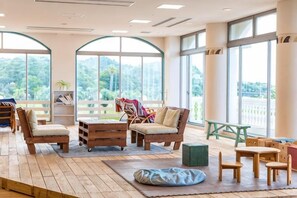 Una habitación amplia con ventanas grandes, muebles de madera y vistas a zonas verdes.
